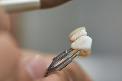 Close-up of hand holding artificial teeth