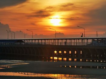 Illuminated bridge against sky during sunset