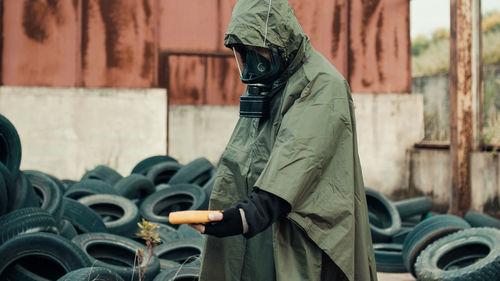 Man with radiation mask and geiger counter checks a nuclear site