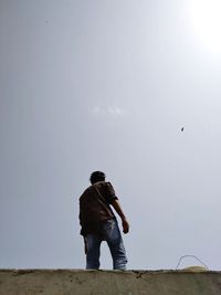 Rear view of man standing against sky