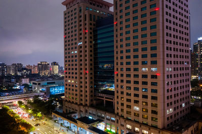 Illuminated buildings in city against sky