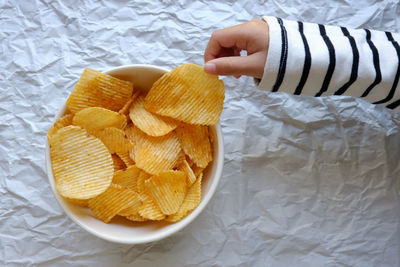 Close-up of hand holding potato chip