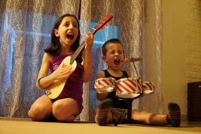 Portrait of happy friends sitting on floor