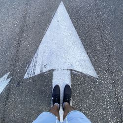 Low section of man standing on road