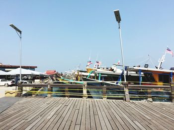 Boats moored at harbor against clear sky