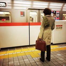 Rear view of woman standing in railroad station