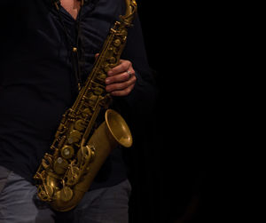 Midsection of man playing saxophone