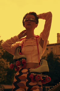 Low angle view of woman standing against sky during sunset