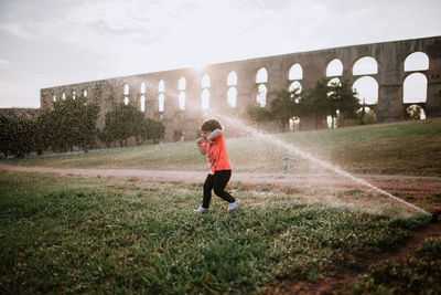 Full length side view of child on landscape against sky