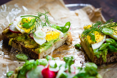 High angle view of open faced sandwiches on wax paper