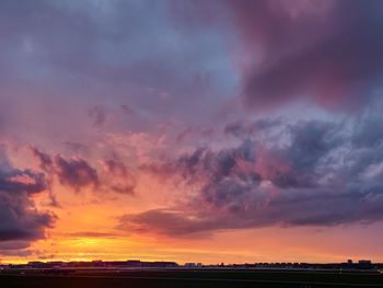 Silhouette landscape against dramatic sky during sunset