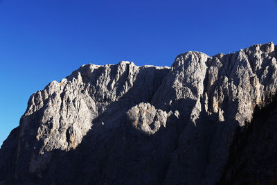 Low angle view of rock formation against clear blue sky