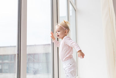 Portrait of young woman looking through window