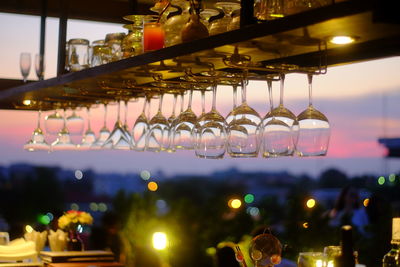 Empty arranged wineglasses in restaurant during sunset