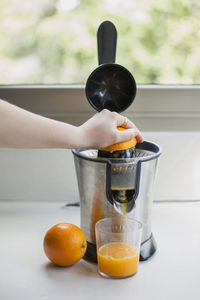 Close-up of hand holding orange juice