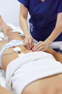 Midsection of woman lying on bed