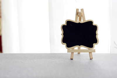 Close-up of chair on table against white wall
