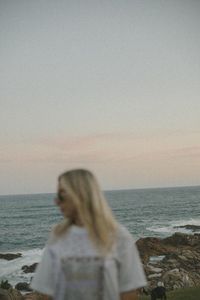 Rear view of woman looking at sea against clear sky