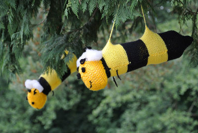 Knitted bees suspended from tree