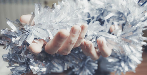 Close-up of hands holding tinsel