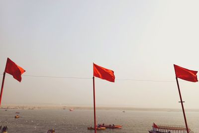 Flag on beach against clear sky