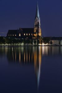 Reflection of building in lake at night