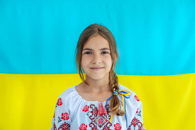 Portrait of smiling girl in front of ukrainian flag