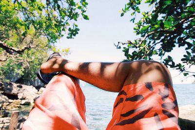 Cropped image of man sitting against sea