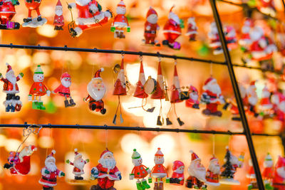 Full frame shot of christmas figurines hanging on metal in store