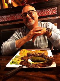 Midsection of man sitting on table at restaurant