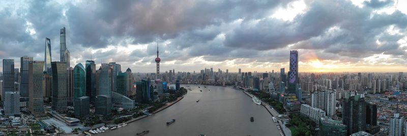 Panoramic view of buildings against cloudy sky