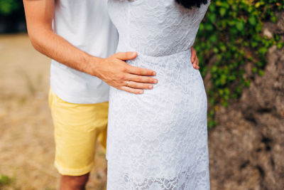 Midsection of woman holding woman standing outdoors