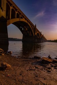 Bridge over river against sky during sunset