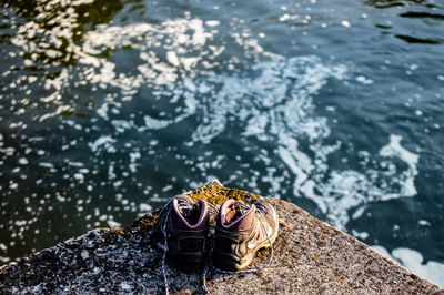 High angle view of shoes on retaining wall by sea