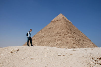 Full length of man standing on desert against clear sky