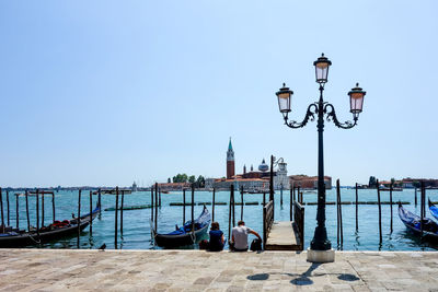 Street light on jetty against clear sky