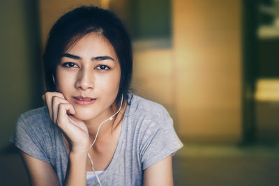 Side view of woman listening music at home