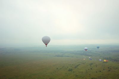 Hot air balloons flying over landscape