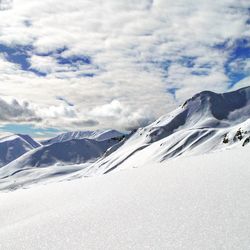 Scenic view of snow covered mountains against cloudy sky at hatcher pass