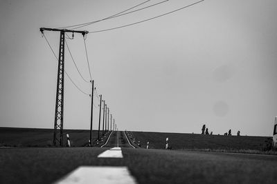 Low angle view of electricity pylon against clear sky