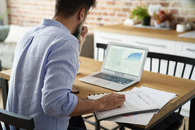 Rear view of man working at office