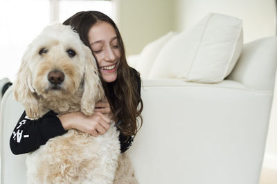 Young girl with her dog on a white couch