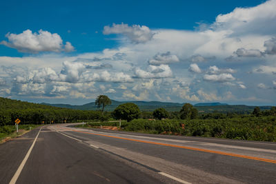 Road leading towards mountains against sky