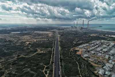 High angle view of factory by sea against sky