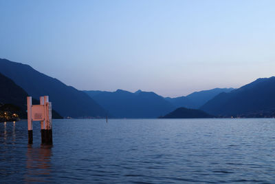 Scenic view of lake by mountains against clear sky