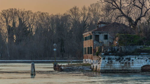 Houses by lake against sky