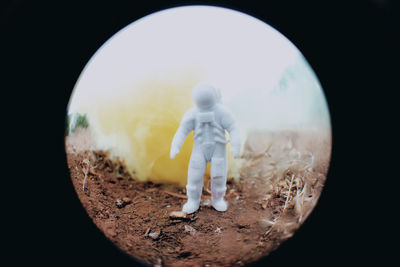 Digital composite image of figurine against sky