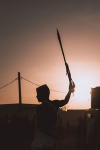 Silhouette shot of a man holding a sword in a traditional sudanese wedding ceremony 