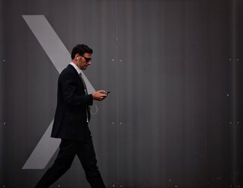 Full length of young man standing on wall