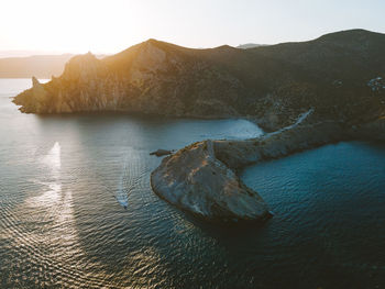 Scenic view of sea and mountains against sky